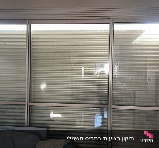 תריסים סגורים על חלון זכוכית גדול